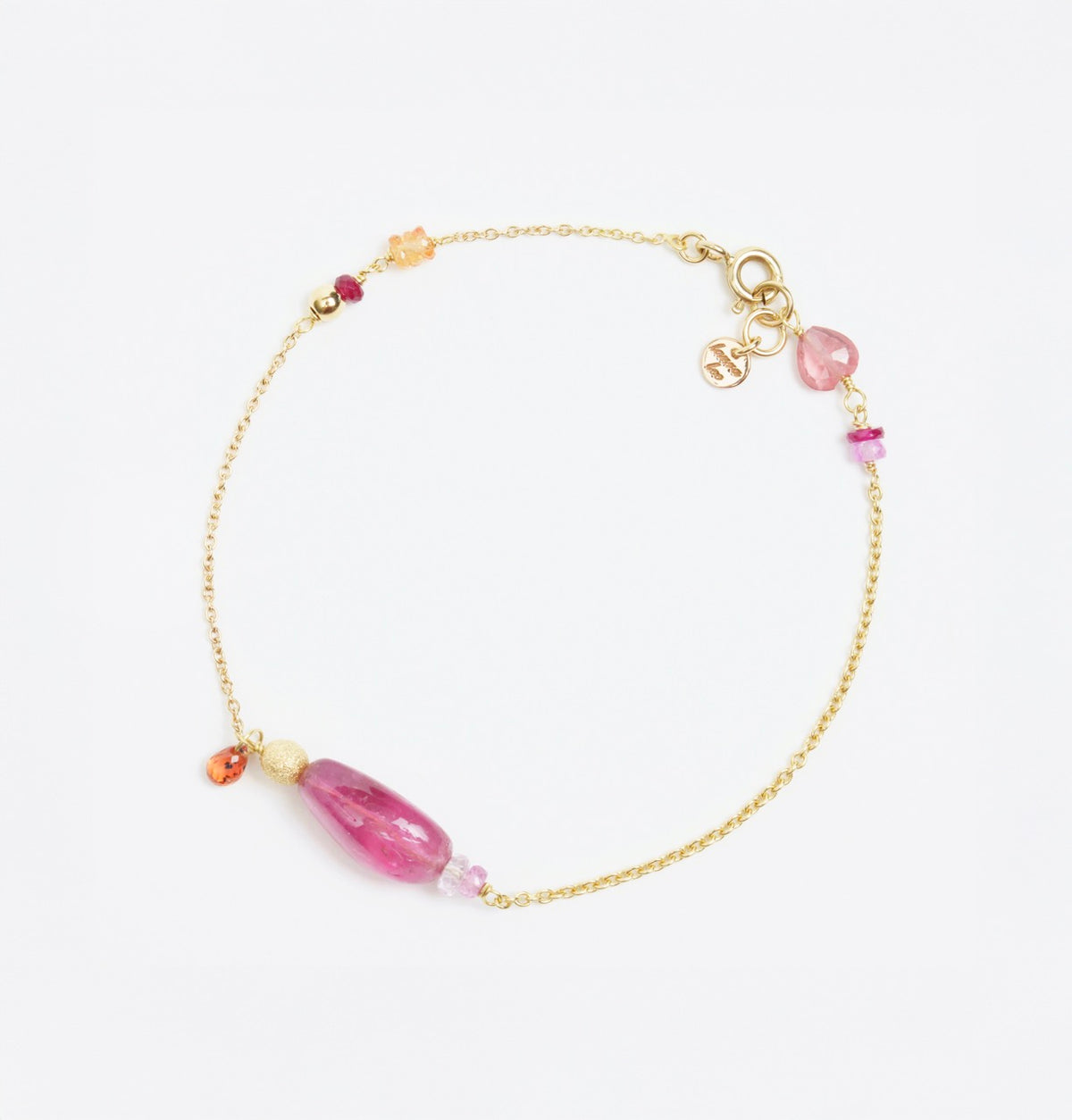 Gold bracelet featuring smooth pink tourmaline, orange and pink sapphires, and gold disco ball accents.