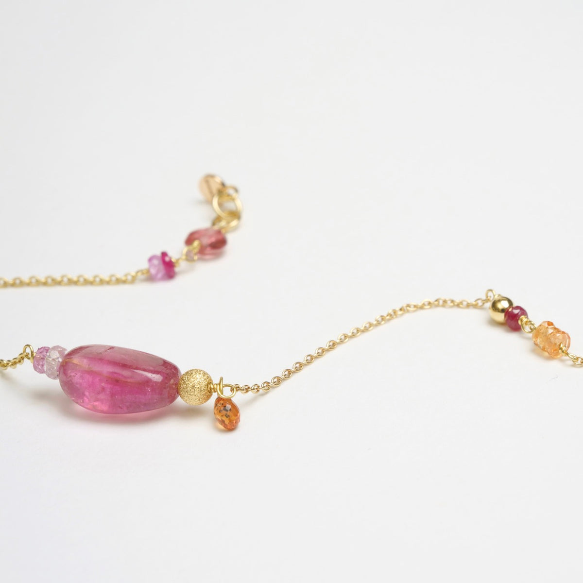Bronzewing Bracelet 3 featuring smooth pink tourmaline, orange and pink sapphires, and 18ct yellow gold chain.