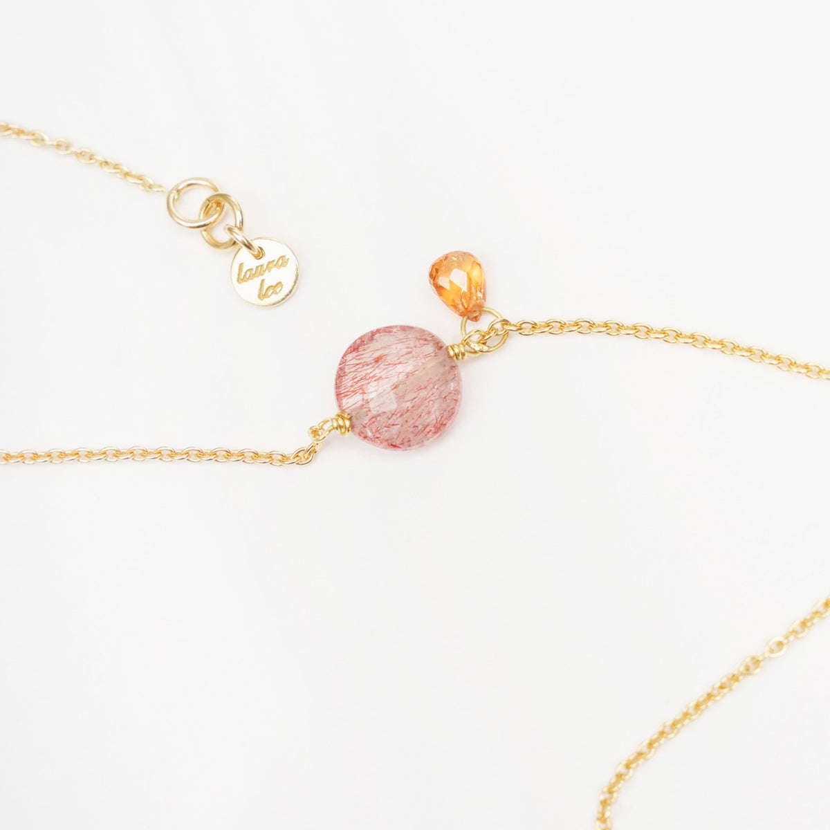 Strawberry Quartz Coin bracelet with a gold chain, featuring an orange sapphire drop, stylish and delicate design.