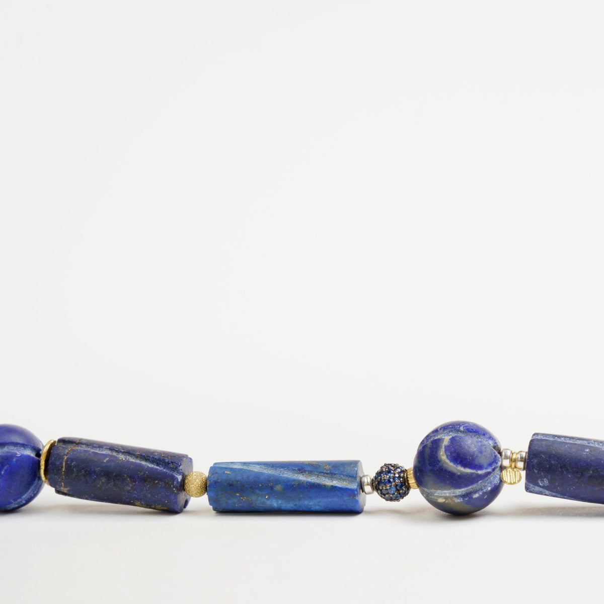 Bold Hippie Trail Bracelet featuring antique lapis lazuli beads in varying shapes, accented with gold detailing.