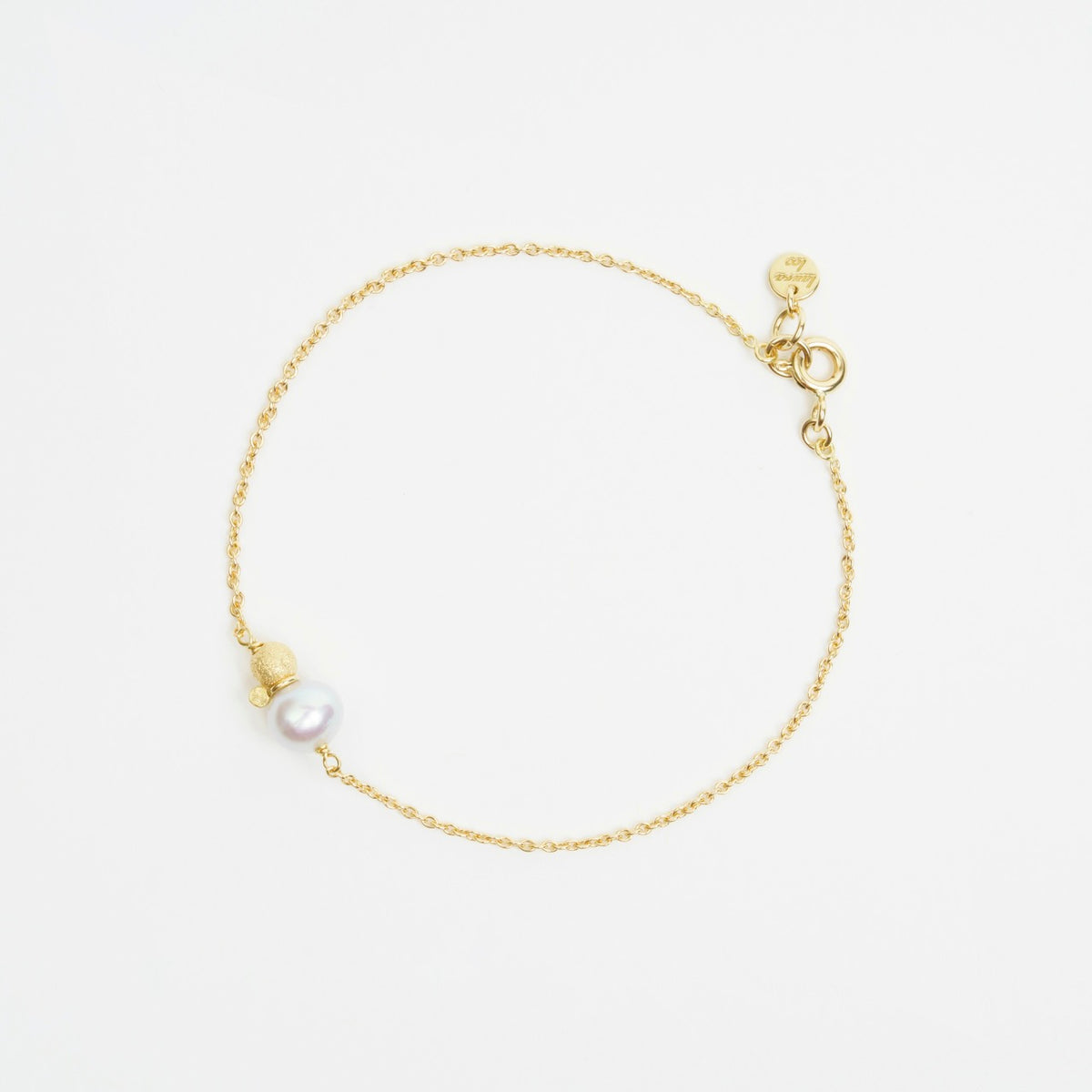Delicate 18ct yellow gold trace chain bracelet featuring a 6.5mm freshwater pearl and a 4mm gold glitter ball.
