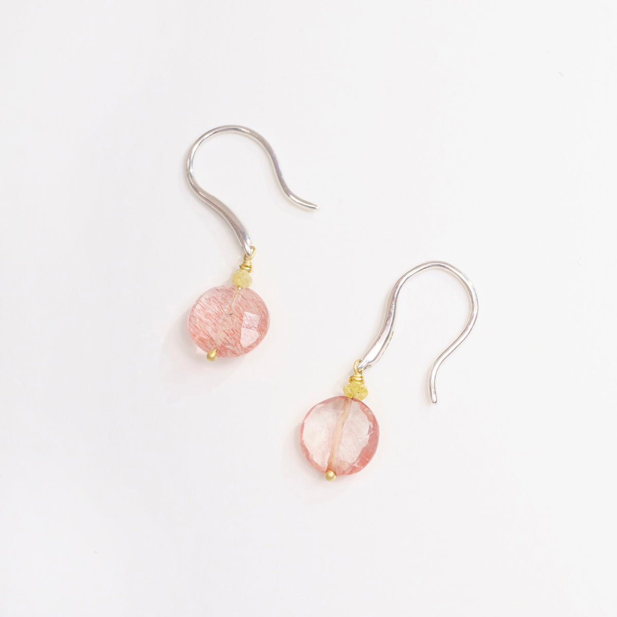 Strawberry Quartz coin earrings with white gold hooks and tiny yellow diamond accents, showcasing a soft pink and gold color palette.