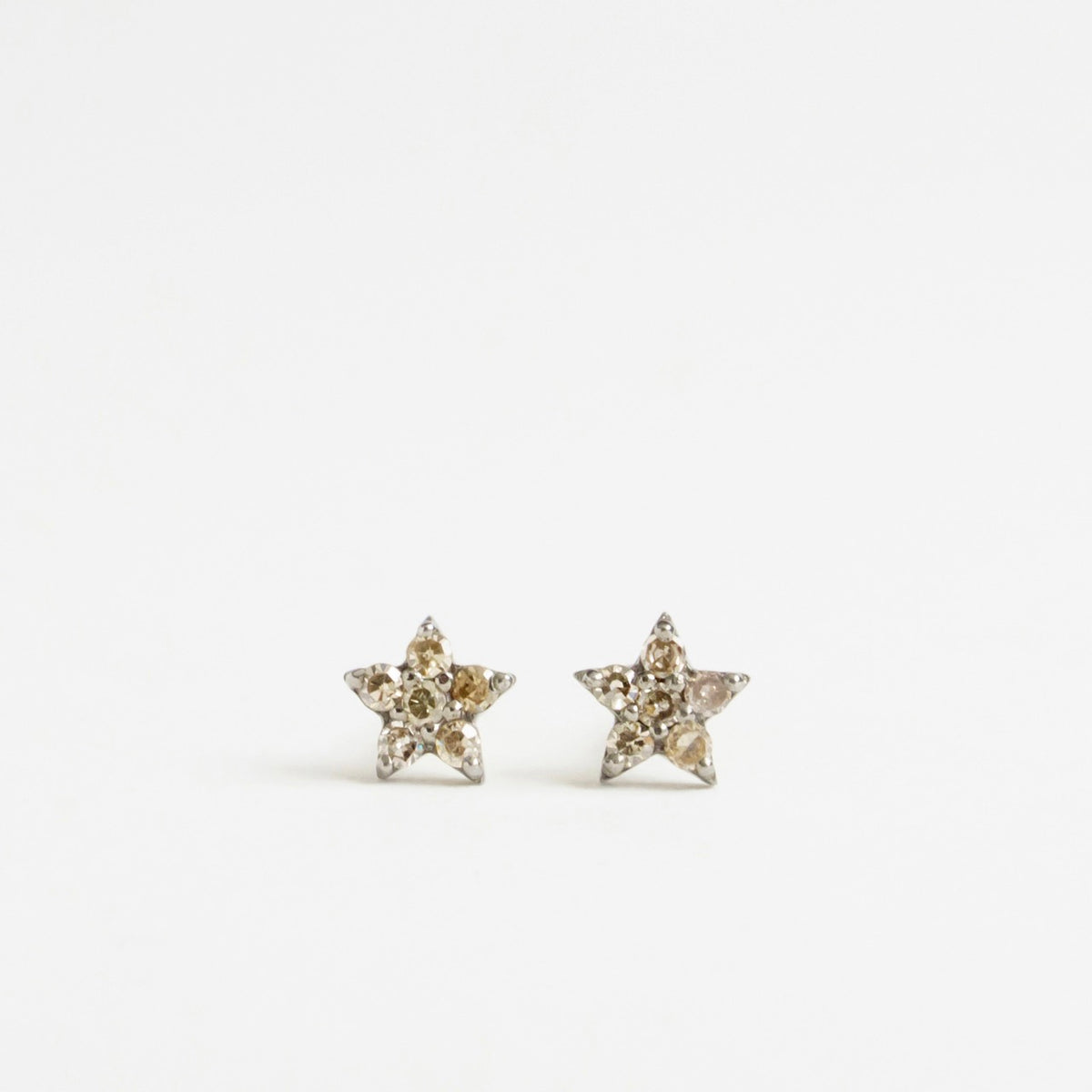 Silver and 9ct yellow gold star-shaped earrings featuring salt and pepper diamonds. Each star measures 5mm.