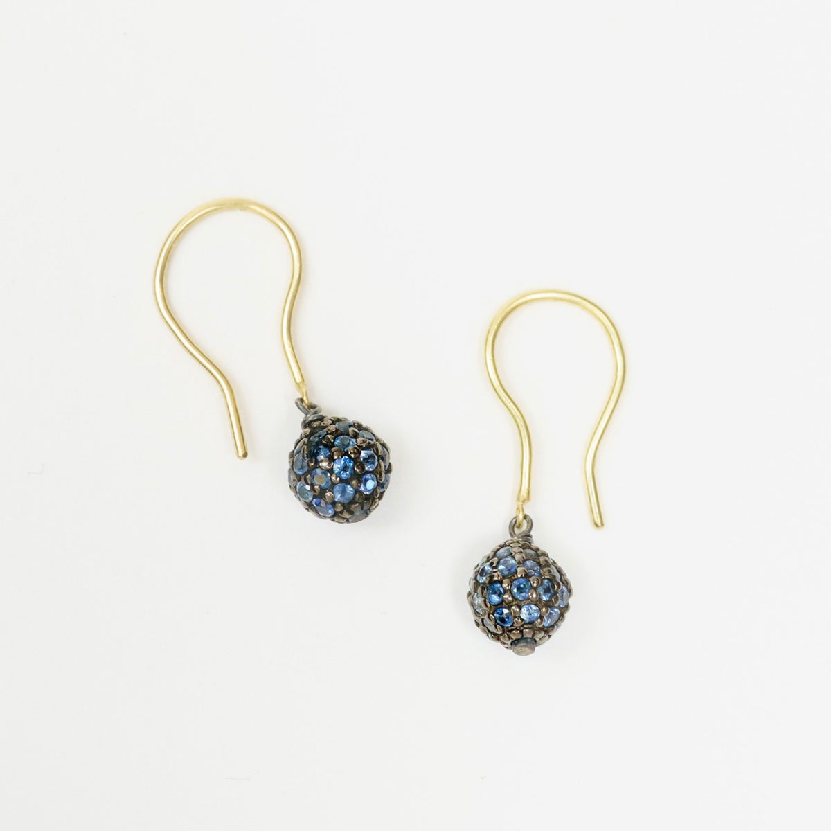 Blue sapphire drop earrings featuring a round bead design in blackened sterling silver, with 18ct yellow gold hooks.