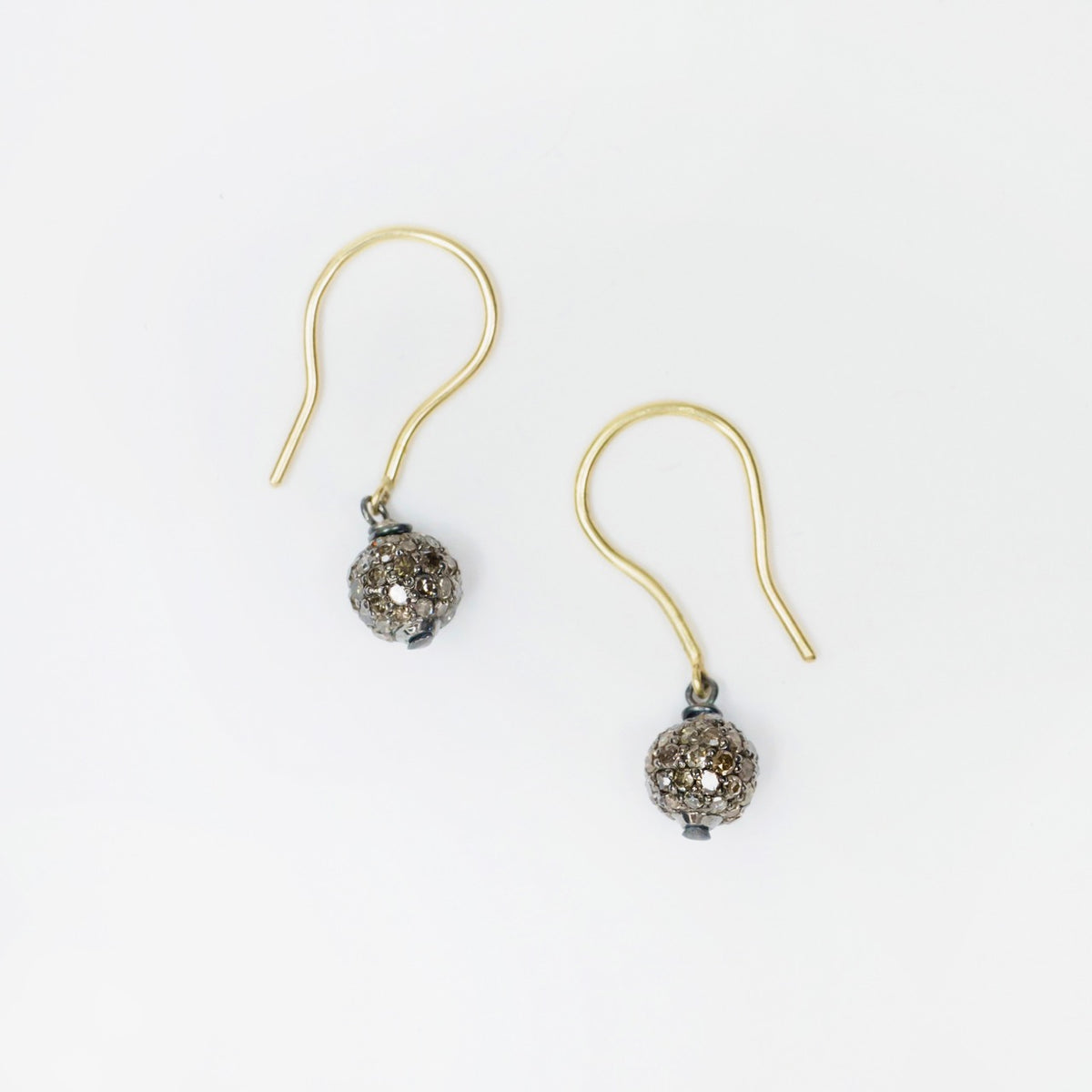 Blackened sterling silver drop earrings featuring 6mm salt and pepper diamond globes with 18k yellow gold hooks.