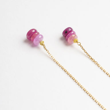 Raspberry-toned sapphire beads drop from a delicate 18ct yellow gold chain, creating elegant thread-through earrings.