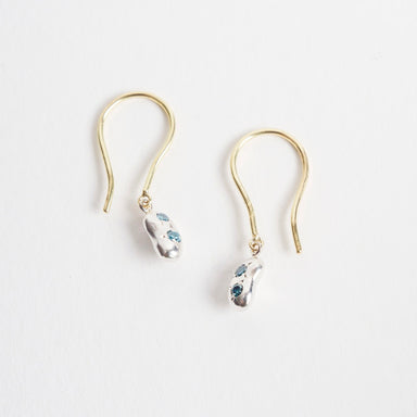 Mini Bean Drops earrings feature silver bean shapes adorned with teal diamonds, suspended from 18ct yellow gold hooks.
