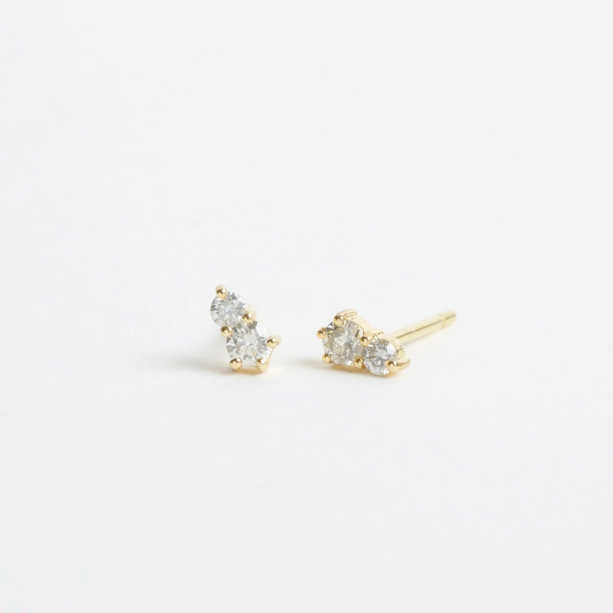 Stud earrings featuring three sparkling silver diamonds set in 18ct yellow gold, showcasing a delicate and classic design.