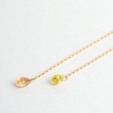 Sapphire briolettes in shades of pink and yellow drop from refined 18ct yellow gold chains, measuring 10cm in length.