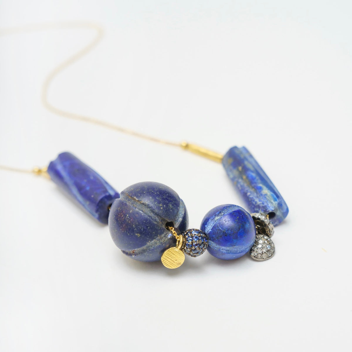 Hippy Trail Necklace 1 features vintage lapis lazuli beads in blue, gold sequins, and blackened silver accents on a gold chain.