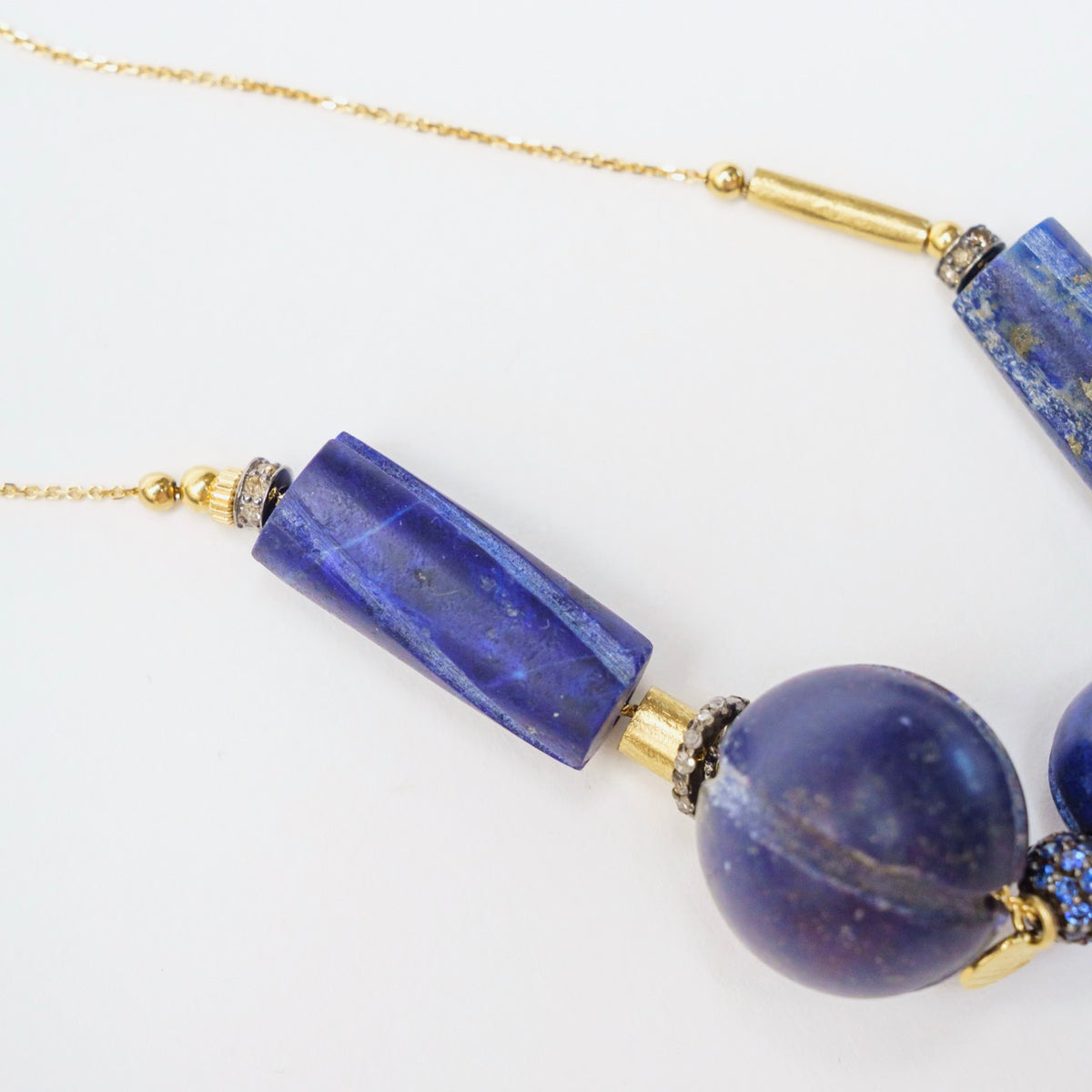 Vintage lapis lazuli beads in round and rectangular shapes are accented with gold sequins and blackened silver.