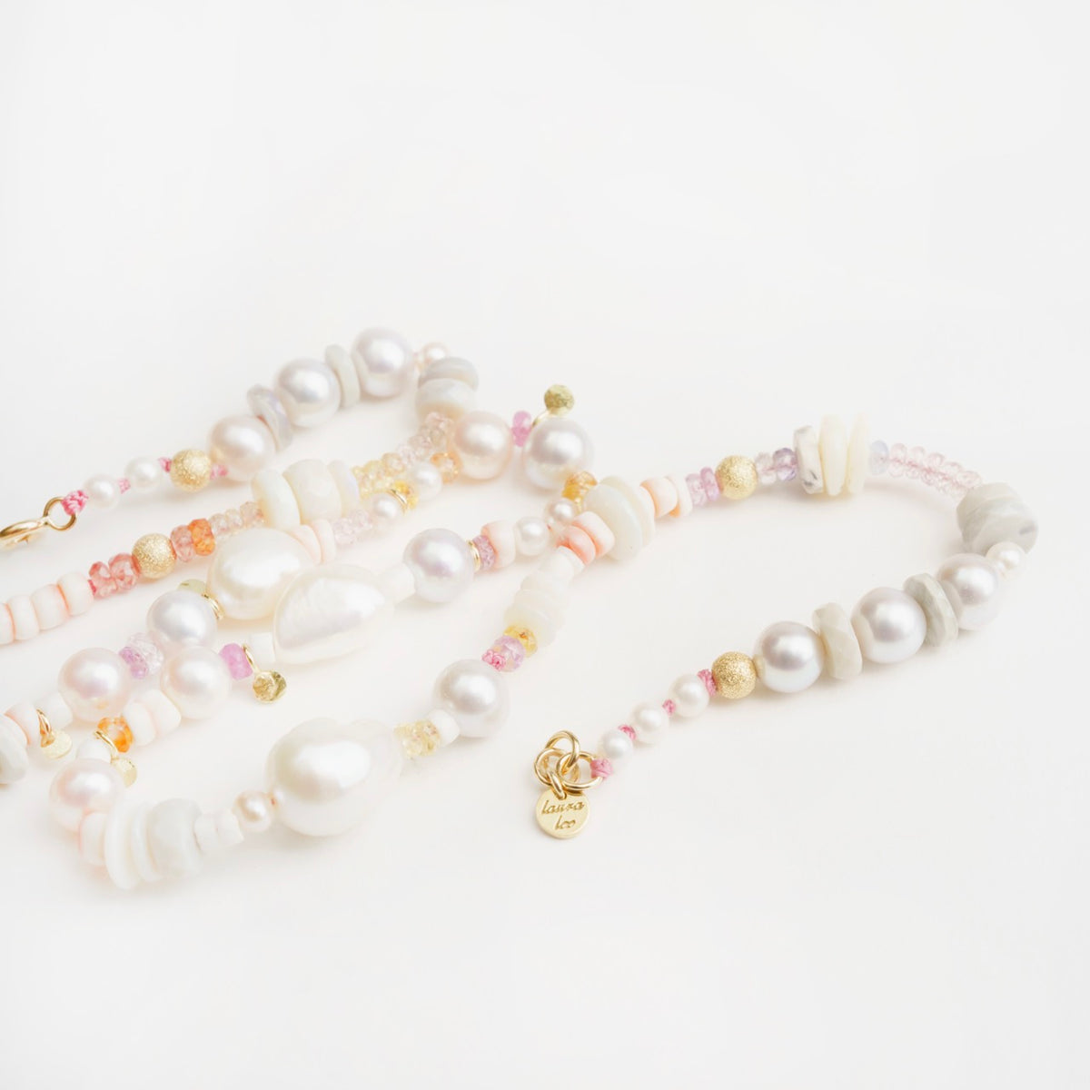 Delicate Corella Choker featuring white and lavender pearls, grey and white opals, and colorful sapphires, accented with gold beads.