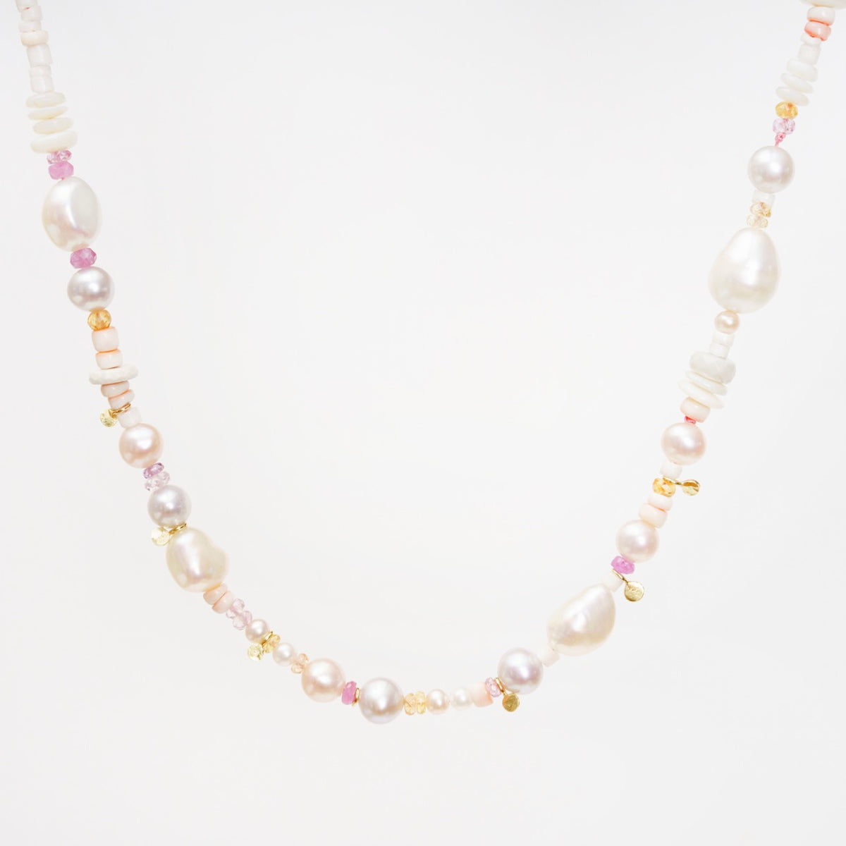 Corella Choker featuring a mix of white and lavender pearls, colorful sapphires, and gold accents, designed to sit on the collarbone.