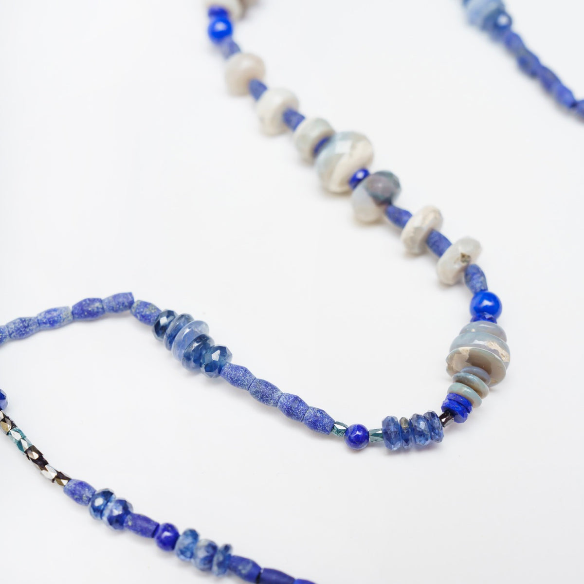 Hand-knotted choker featuring vintage beads in various shades of blue, including lapis lazuli and opals, with a gold clasp.