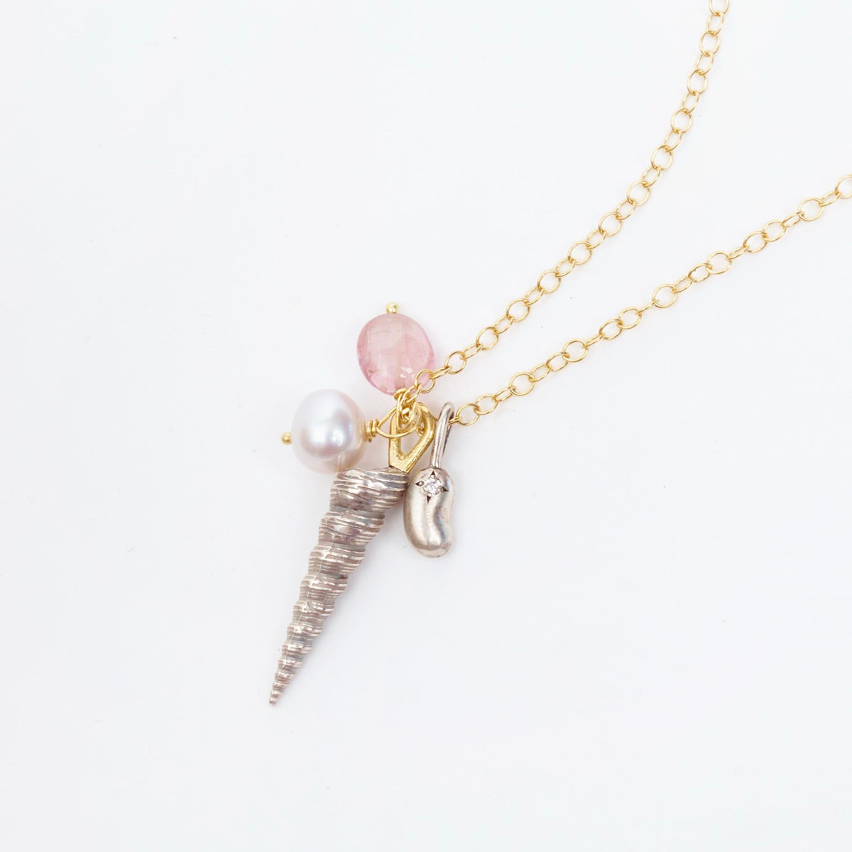 Silver shell charm and pink tourmaline bead on a 19" yellow gold chain necklace, accented with a tiny diamond bean.