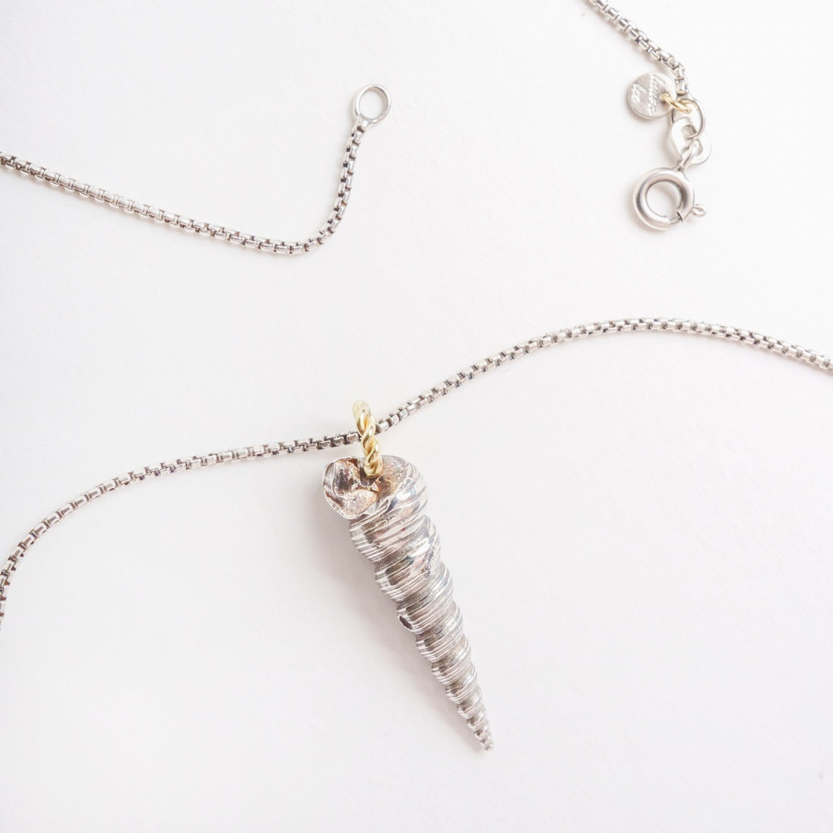 Solid silver Larrakia shell pendant with a handmade 18ct yellow gold rope link, hanging on a blackened silver chain.