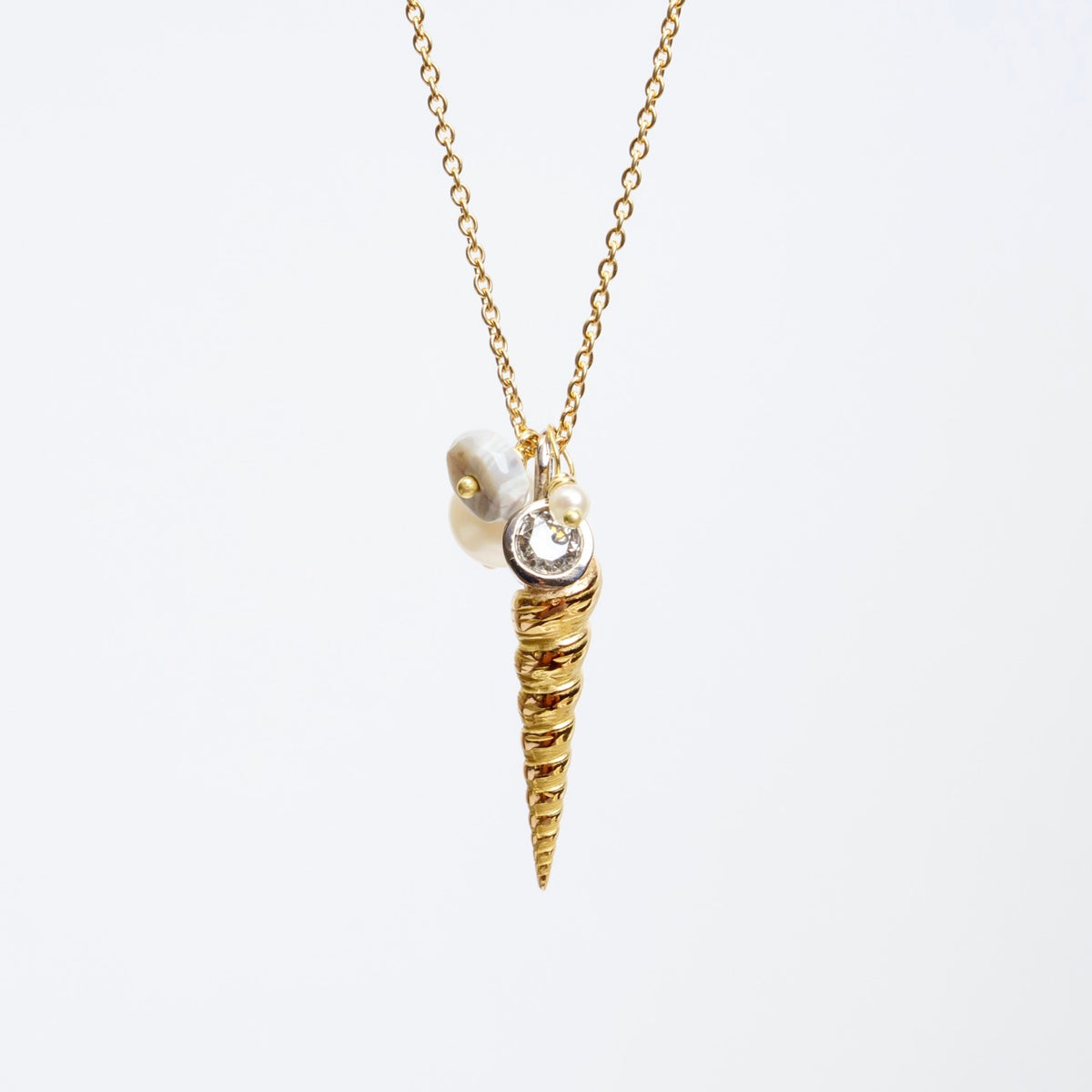 Luxe Larrakia Shell Cluster Necklace featuring a rose gold shell, silver diamond, and freshwater pearl details on a gold chain.
