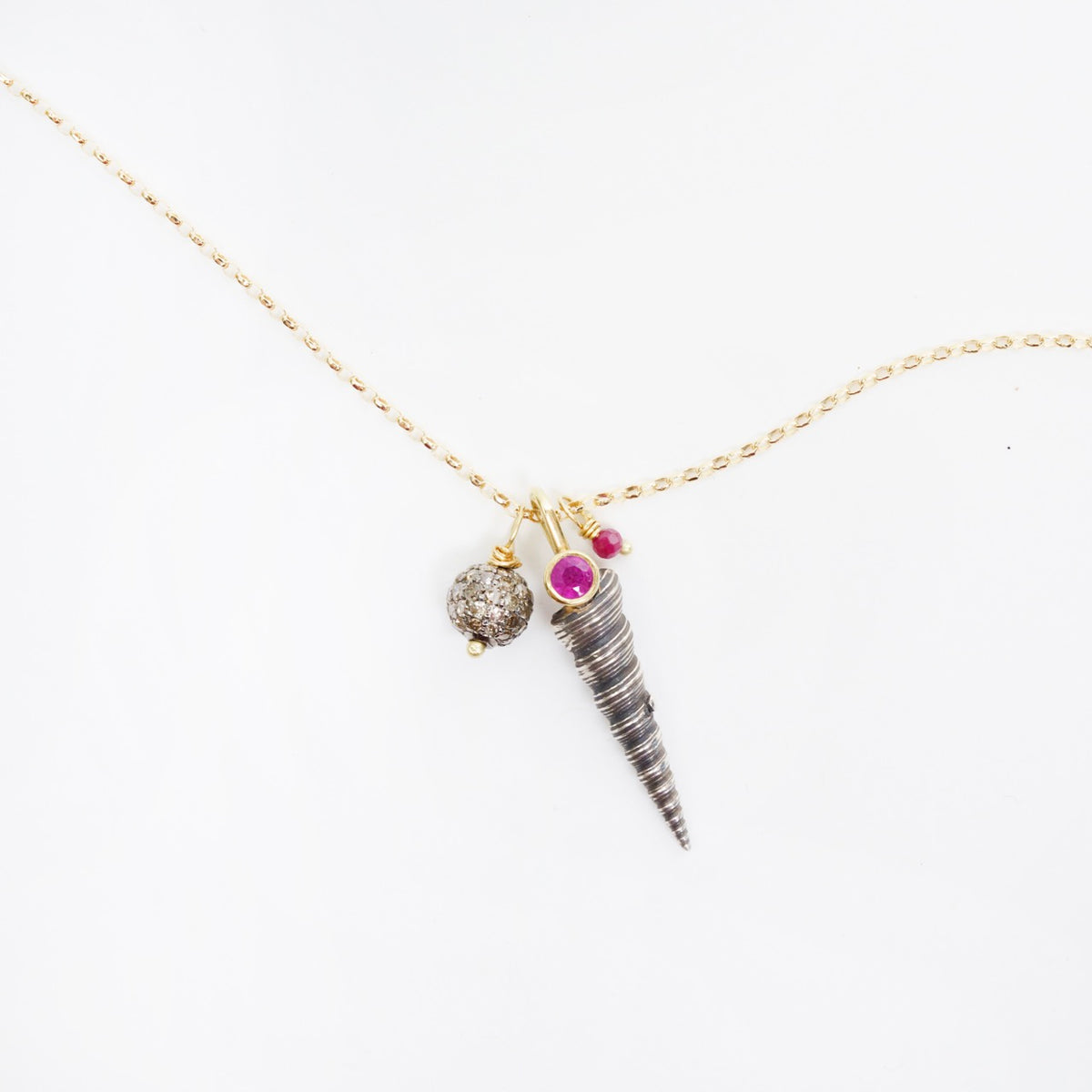 Silver shell pendant with rubies and champagne diamond accents on an 18" yellow gold chain.