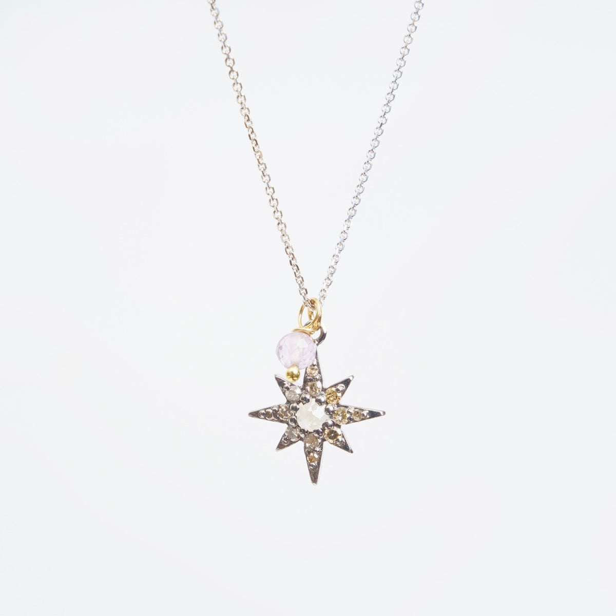 Southern Star Necklace features a blackened silver star pendant with sparkling diamonds and a lavender spinel, on a 20" white gold chain.