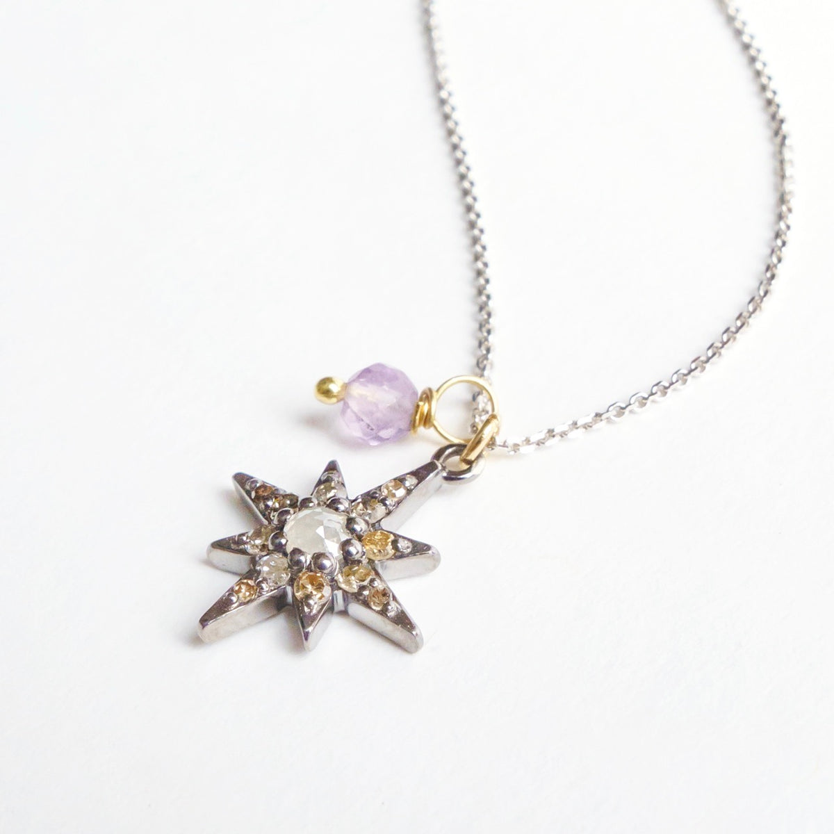 Southern Star Necklace features a silver star pendant with diamond accents, lavender spinel detail, and a 20" white gold chain.