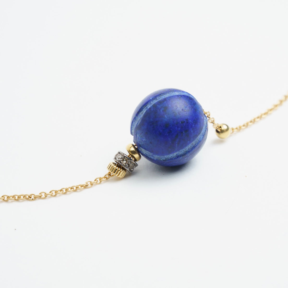 Cluster of antique lapis lazuli bead with 18ct gold chain and diamond accents, showcasing chic elegance.