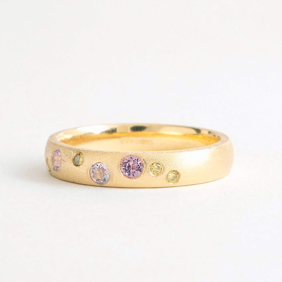 Wide band ring in 18ct yellow gold, featuring gypsy-set pink spinels and canary yellow diamonds.