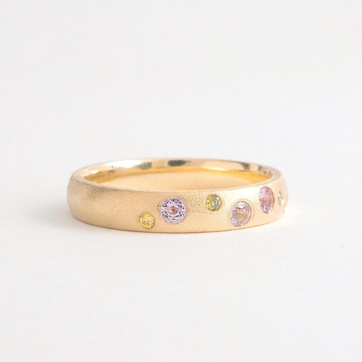 Wide band ring in 18ct yellow gold with scattered pink spinels and canary yellow diamonds.