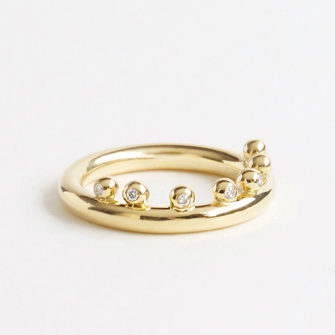 18ct yellow gold ring featuring seven bubble-like accents and small sparkling diamonds, showcasing a smooth round band.