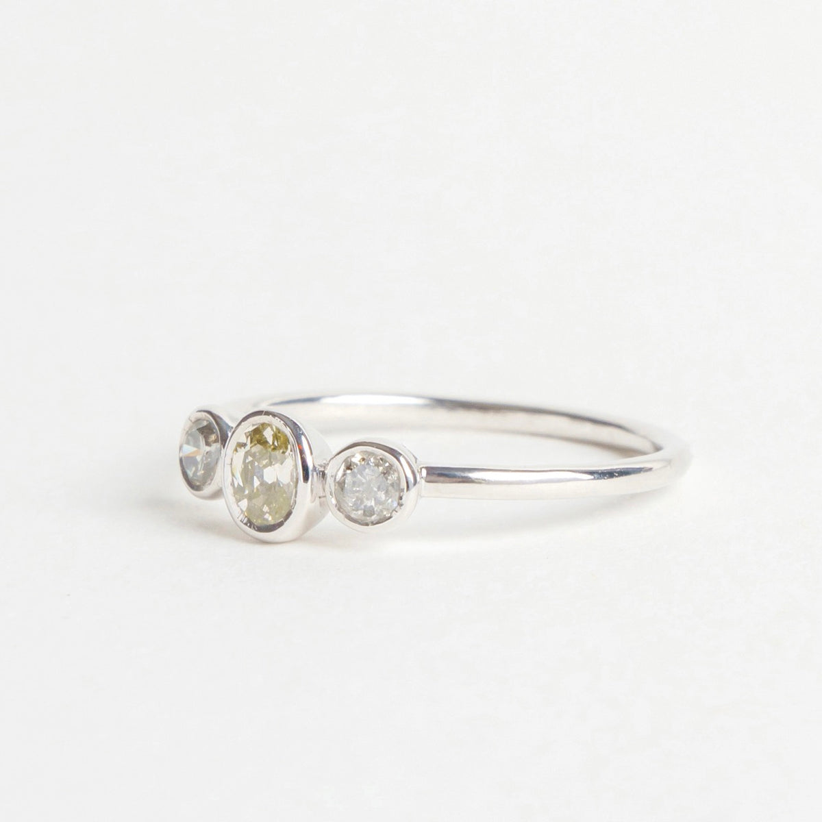 Djulpan Trilogy Ring featuring three mixed-tone, round and oval diamonds set in an 18ct white gold band.
