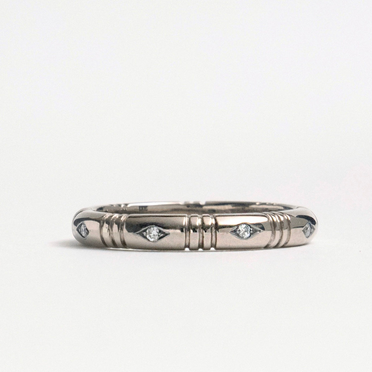 Banded ring in 18ct white gold, featuring eight small diamonds in a rhombus shape, designed for stacking.
